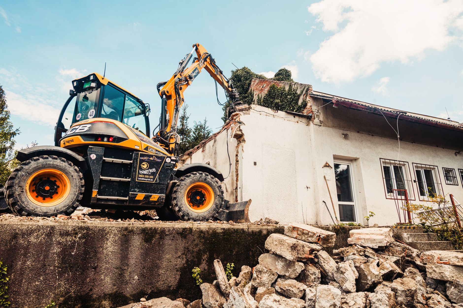 Powerful excavator tearing down an old house during a demolition project outdoors